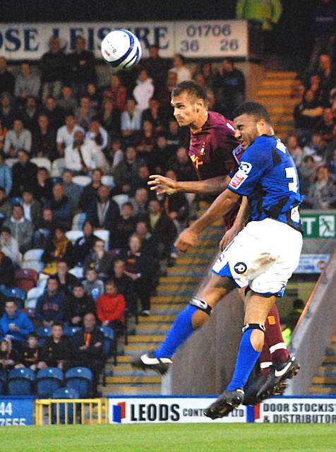 Evans and Holness challenge for a header.