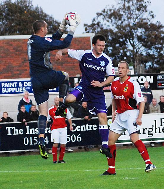 Barry Roche gathers the ball in front of Chris Dagnall.