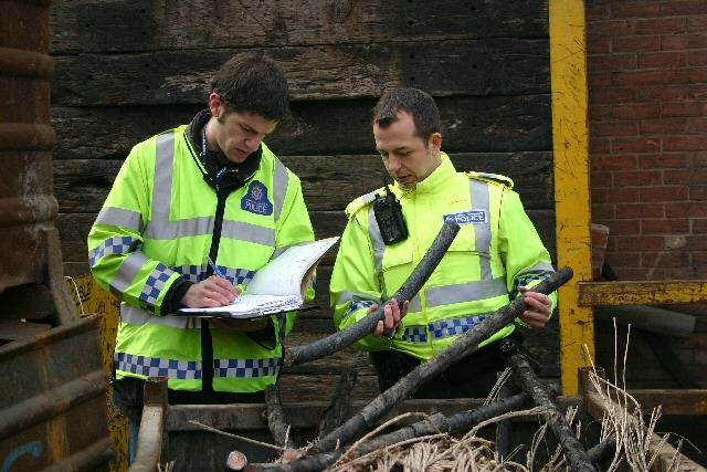 Officers look for stolen cable at a scrap yard