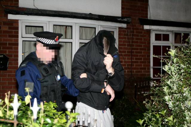 A suspect being led to a police van 