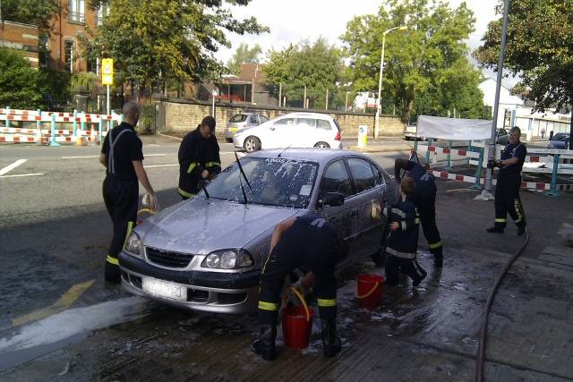 Fire fighters in Rochdale cleaning a car at the charity car wash