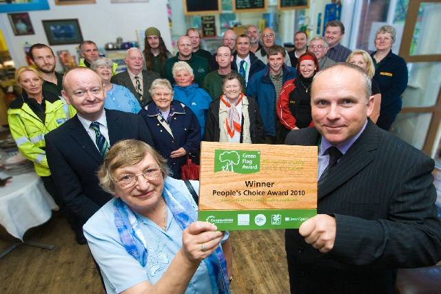 Queen’s Park friends group chairwoman, Sheila Hill, and Rochdale Borough Council’s Parks and Street Scene Manager Mick Ripley hold up the People’s Choice Award plaque presented by Keep Britain Tidy’s Paul Todd. Behind them are the friends group members, parks staff, police officers and other volunteers whose input has helped to make Queen’s Park officially the nation’s favourite