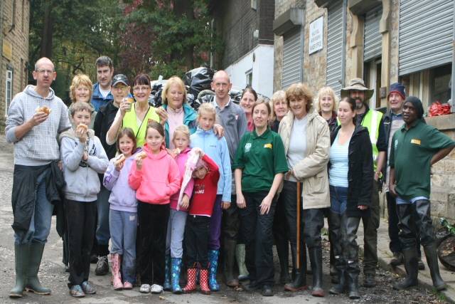 The group of volunteers infront of a trailer of rubbish enjoying the BBQ food