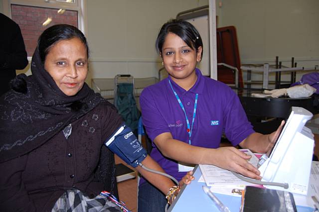 Health Trainer, Sabia Begum takes the blood pressure of a local resident