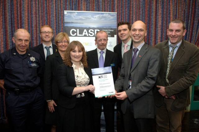 Jan Rowley from Liverpool City Council presents the Award to Adam Hebden GMFRS Environmental Manager and Councillor Paul Ankers GMFRA Member Champion for the Environment (third from right) along with other representatives from the NW Fire & Rescue Services
