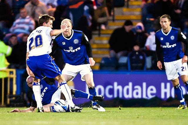 Rochdale 1 - 1 Oldham<br />Gary Jones tackles Dale Stephens from the floor as Jason Kennedy watches