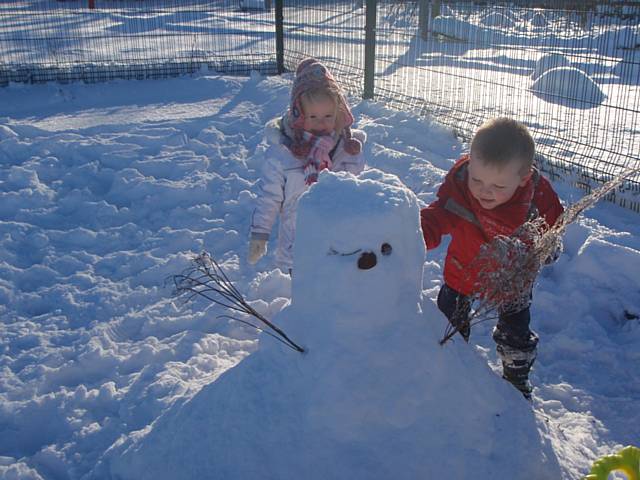 Sure Start children Lucy Fraser and Jay Anderson busy building their snowman at Langley Children's Centre.