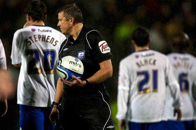 Rochdale v Oldham Athletic – abandoned due to torrential rain rendering the playing surface dangerous - the referee, Tony Bates, retrieves the ball and orders the players off the pitch