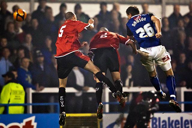 Rochdale v FC United of Manchester - Craig Dawson jumps highest and powers a header goalwards