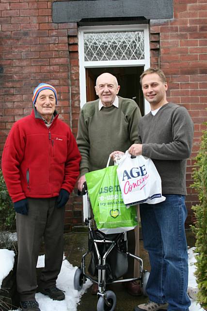 Elderly resident Roger Wareing receives a food parcel from Paul Gala and Lyndon Price of Age Concern.