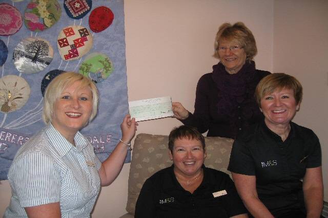 Dorothy Swire receiving a cheque from Sarah Kaye and M & S staff