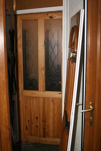 The front door is removed from its frame as police burst into the house.