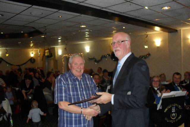 Peter Bates presents Jim Fitton with a certificate for 25 years service to brass banding 