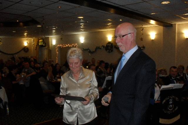 Peter Bates presents Val Fitton with a certificate for 25 years service to brass banding 