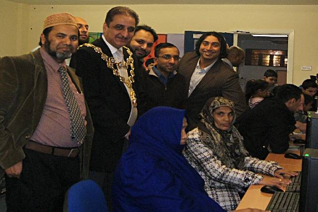 Syed Mashuk Miah,the Mayor of Rochdale, Shaukat Ali- Vice Chairman of WCCA and Hellal Choudhury- Chairman of WCCA and Councillor Farooq Ahmed over looking a couple ladies having a go on the computers