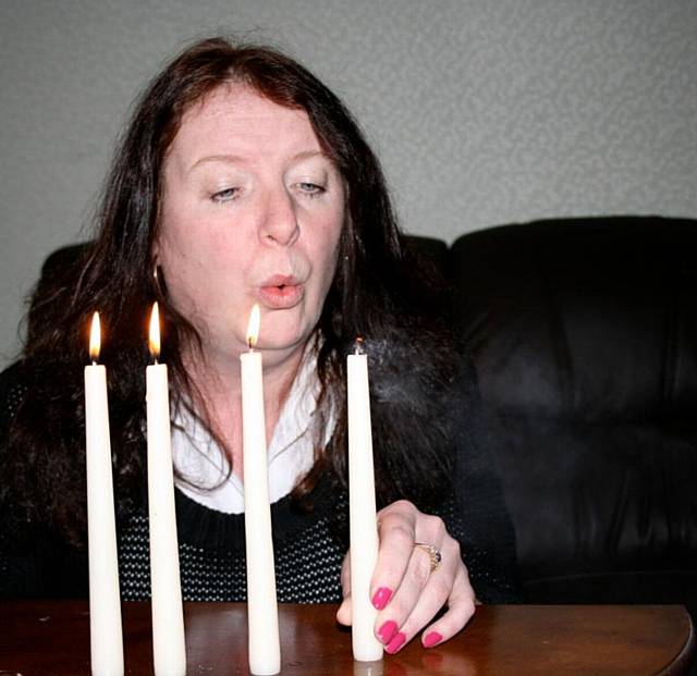 Kerry Reddy, Manager at Rochdale’s Omega Women’s Centre, extinguishes one candle that represents a domestic abuse victim this Christmas