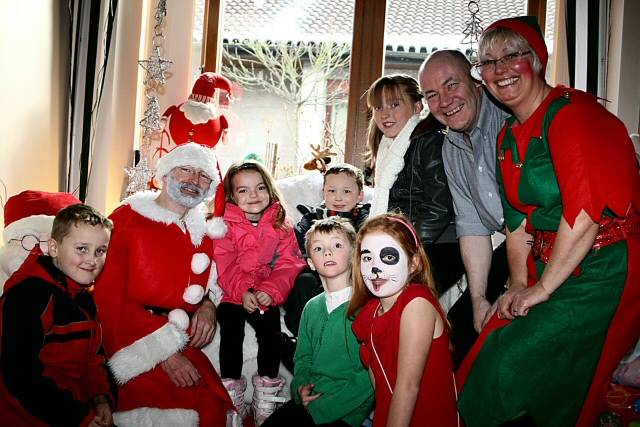 Santa, helpers and Springhill Hopsice Fundraising Manager, Ian Jenkins, surrounded by youngsters 