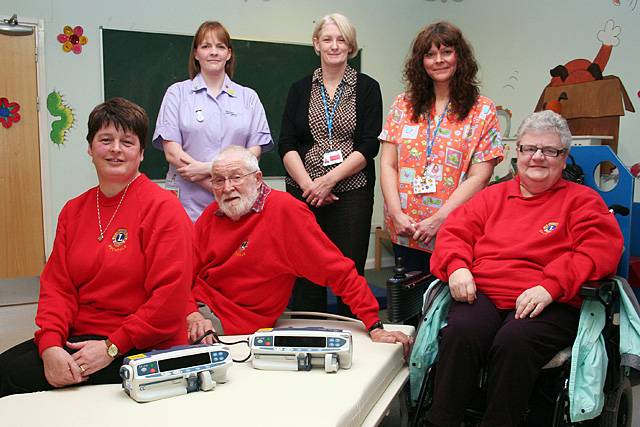 Members of the Rochdale Lions, (seated from left to right) Eileen Taylor, Peter Spencer and Linda Spencer, take a seat on a glideaway bed with syringe pumps, joined by (standing from left to right) Andrea Scholey, Yvonne Tunstall and Louise Gallagher from Rochdale Infirmary’s Children’s Unit