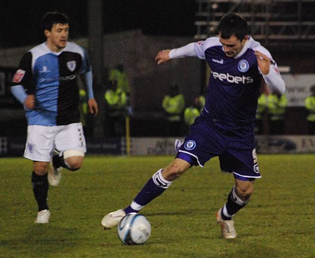 Chris Dagnall drives into the Bury penalty area.