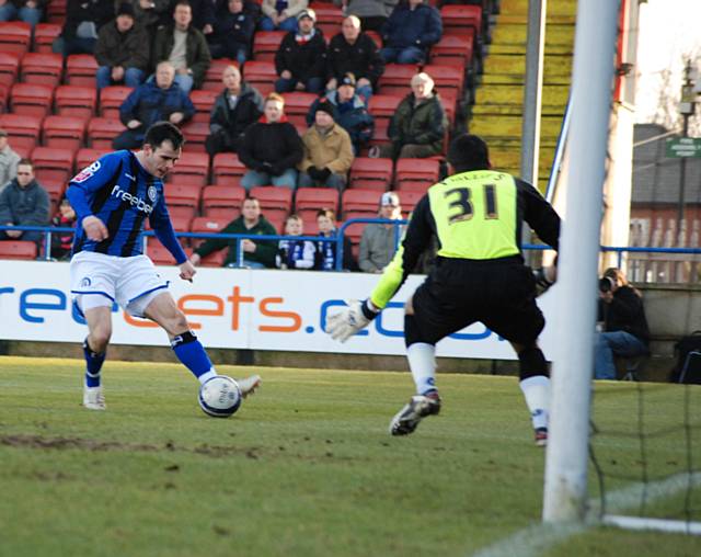 Chris Dagnall shapes to shoot low under Steve Phillips.