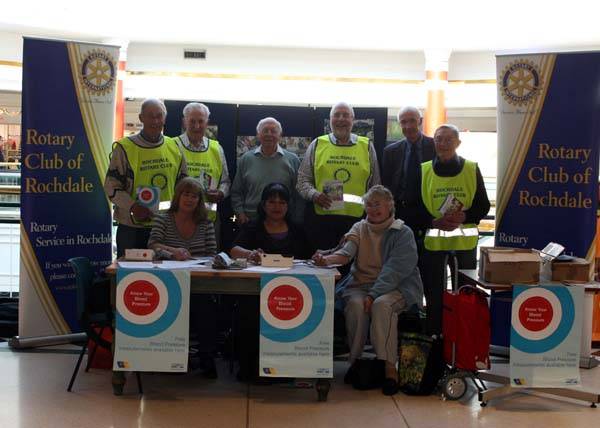 The Rotary Club of Rochdale with the blood pressure team and one shopper having her blood pressure checked