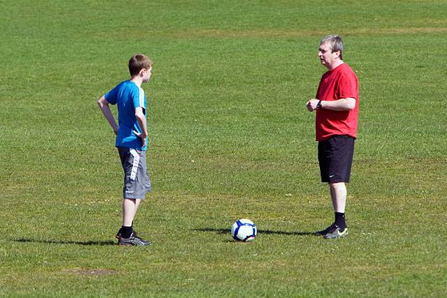 Father and son play football in Springfield Park