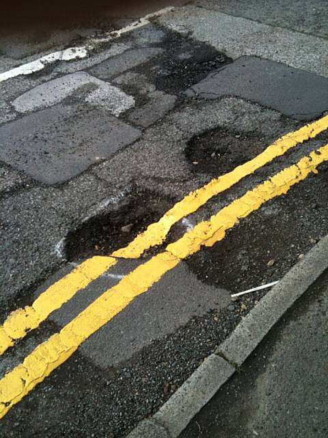 Yellow lines painted over a pothole on Chadwick Hall Road