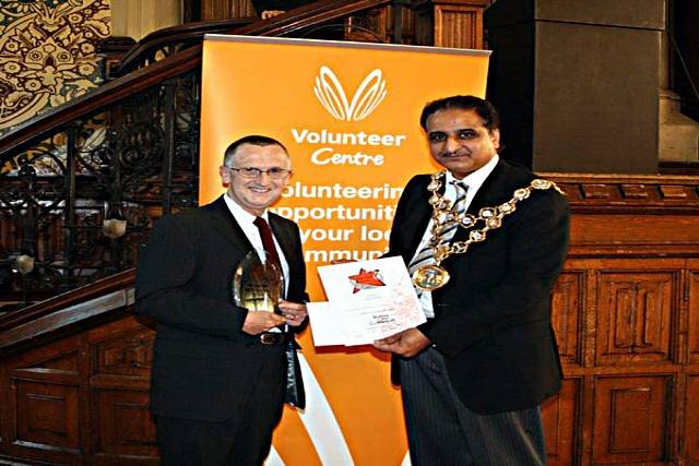 Michael Badham collects his award from the Mayor of Rochdale, Councillor Zulfiqar Ali