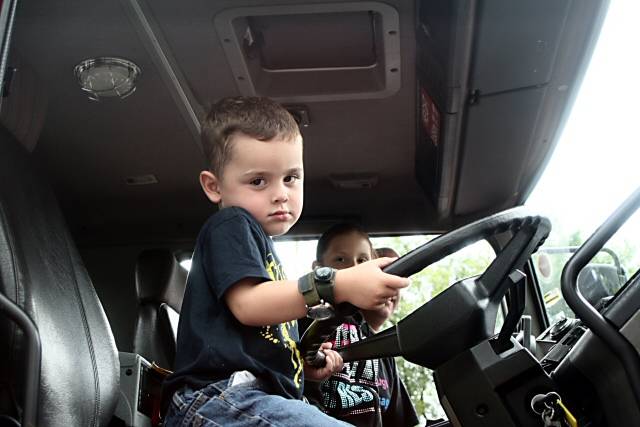 Young boy enjoys sitting in a fire engine