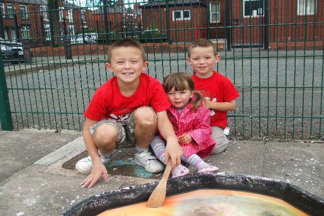 Christopher, Julia and John Wild enjoy the outdoor messy play time