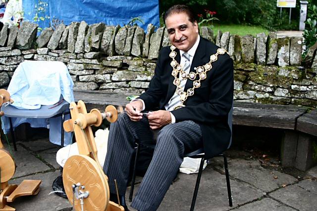 The Mayor of Rochdale, Councillor Zulfiqar Ali having a go at wool spinning