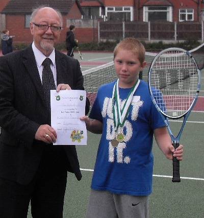 Jim Dobbin MP presenting a member of the tennis camp with a certificate