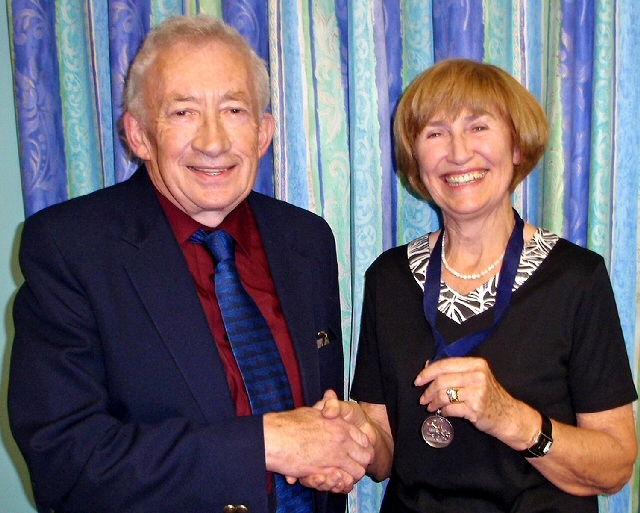 Retiring President Harry Muncaster hands the chain of office to Patricia Noon. 
Photograph courtesy of Bob Srinivas.
