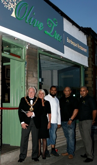 The Mayor and Mayoress of Rochdale cutting a ribbon to The Olive Tree alongside staff members