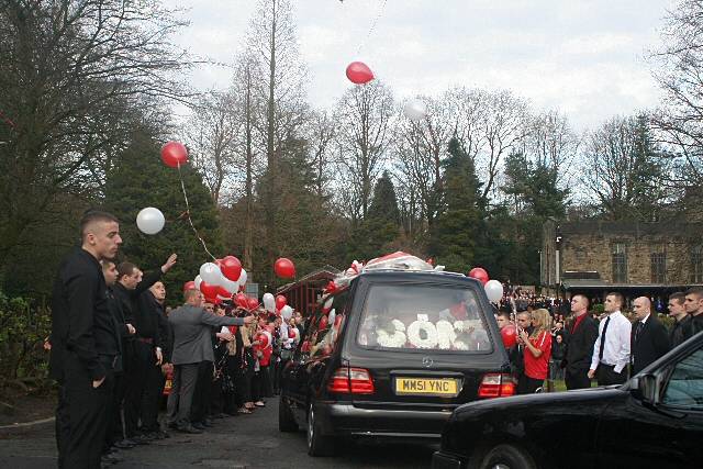 The friends of Danny Wilson let of red and white balloons as the funeral cortege passed through their guard of honour