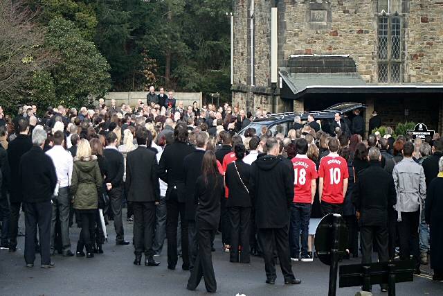 Mourners listening to the service outside the crematorium