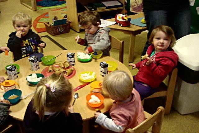 The children enjoying spring rolls, rice, chicken and prawn crackers.  
