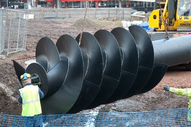 The screw-shaped hydro-electric turbine being put into place