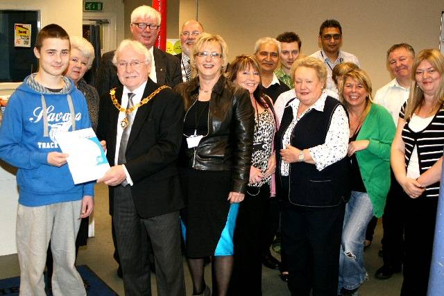 Members of the Rochdale Connections Trust with guests celebrating their Annual Report and Deputy Mayor Alan Godson presenting Daniel Hutton with a certificate