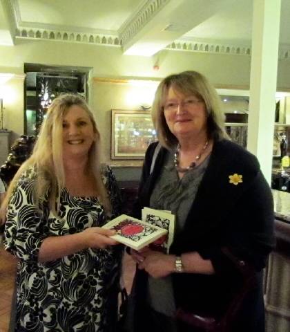 Christine Morgan giving a book to a diner at The Crimble