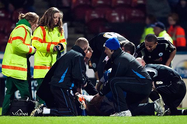 Huddersfield's Anthony Pilkington is treated for an horrific leg injury