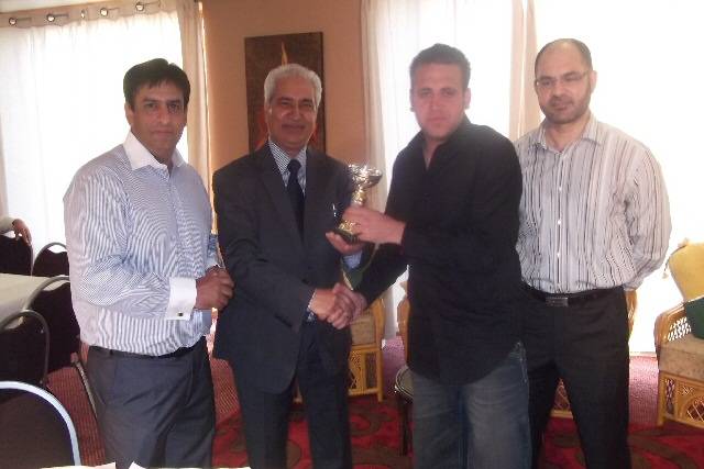 Mr Ghulam presenting a trophy to Saif of Speed Stars 