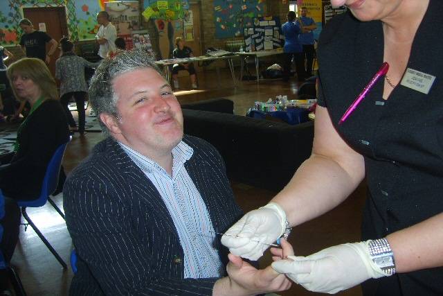 Councillor Dale Mulgrew getting a health check from one of the staff from the Kirkholt medical practice