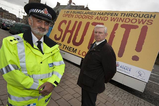 Chief Inspector Mir and Crime Reduction Adviser Brian Farr with an ad van being used to promote home security

