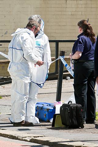 Forensic examiners prepare to enter the disused building to examine the body