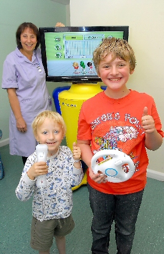 Healthcare assistant Julie Platt watches brothers Gabriel and Oliver busy playing on the fun centre.
