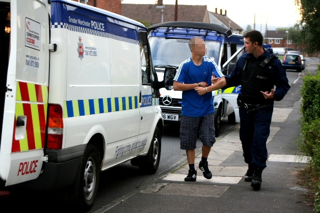 A suspect being led away by a police officer 