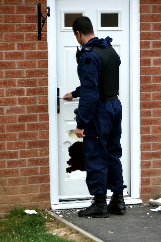 An officer entering a house where the door was damaged by forced entry