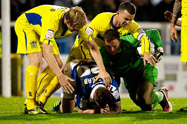 Bury players attack Craig Curran following his challenge on Carson that resulted in his sending off