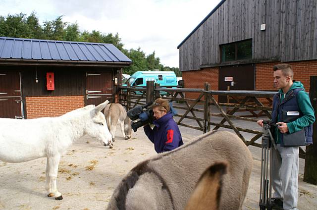 Key Productions director, John O’Hara, on camera and media production student Adam Sykes, 18, from Oldham (right) with the donkeys at Penny Farm in Blackpool.
